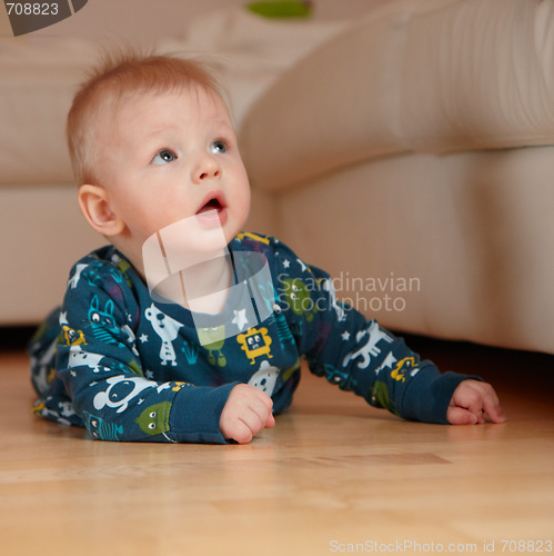 Image of 6 mobth old baby crawling on floor at home