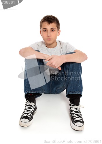 Image of Pre teen boy sitting in jeans and t-shirt