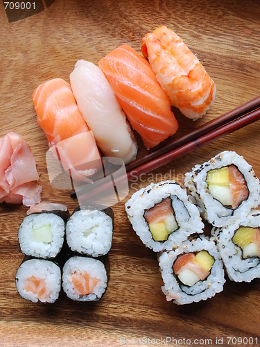 Image of Sushi - Japonese food (on a wooden plate)