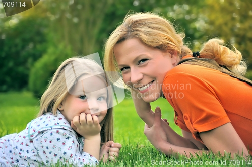 Image of Young mother and daughter laying on the grass