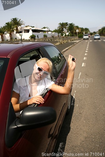 Image of young blonde woman with keys in the car