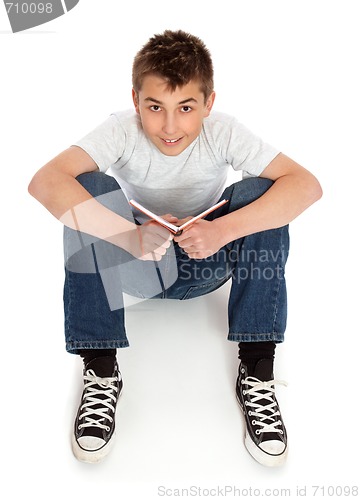 Image of Boy in jeans sitting on floor