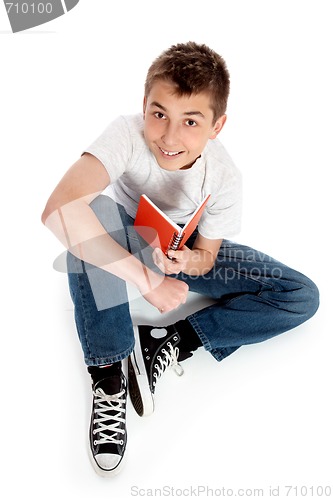 Image of Pre teen boy sitting with a book