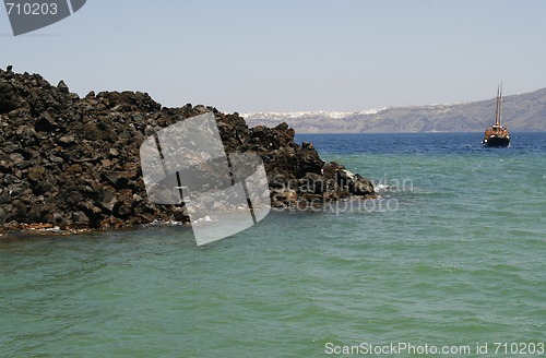 Image of Sail boat sailing in waters by the Santorini island, Greece