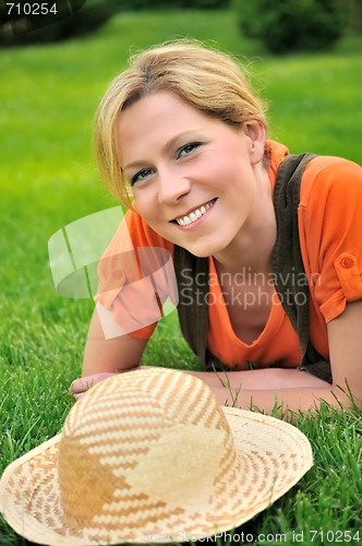 Image of Young woman laying on the grass
