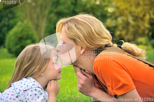 Image of Mother is kissing her daughter