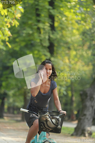 Image of Woman on the phone riding bicycle