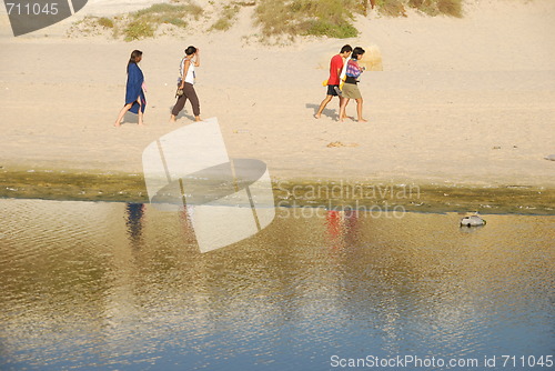 Image of Young brothers/sisters walking on beach