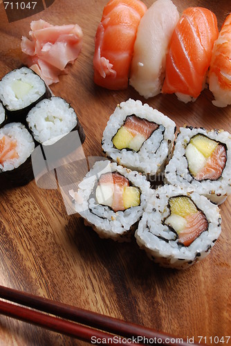 Image of Sushi - Japonese food (on a wooden plate)