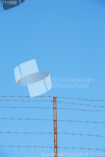 Image of Barbed wire on blue sky background