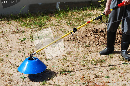 Image of Young farmer fertilizing the soil