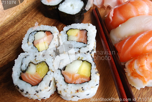 Image of Sushi - Japonese food (on a wooden plate)