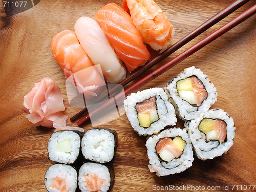 Image of Sushi - Japonese food (on a wooden plate)