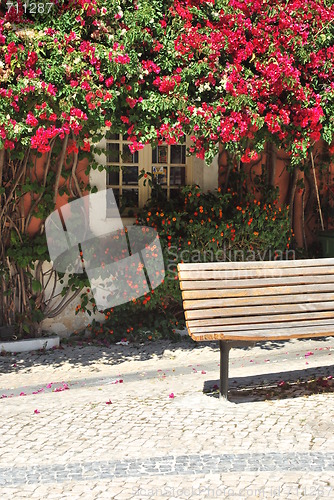 Image of Wooden bench and a typical window with clinging flowers