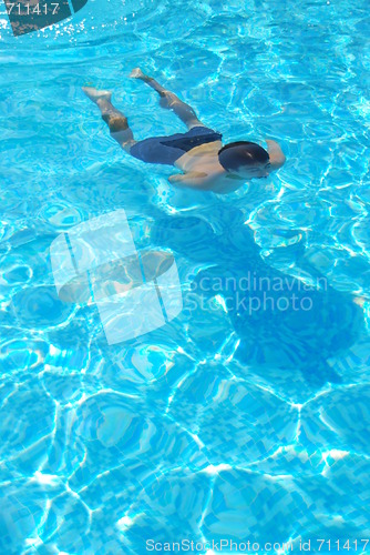 Image of Young man swimming underwater
