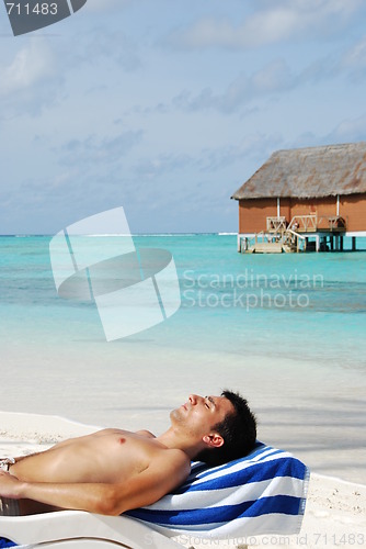 Image of Young man sunbathing in a Maldivian Island beach