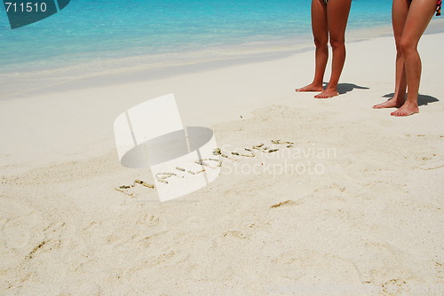 Image of Maldives written in a sandy tropical beach
