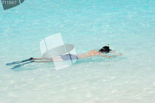 Image of Young man snorkeling in Maldives (blue ocean water)
