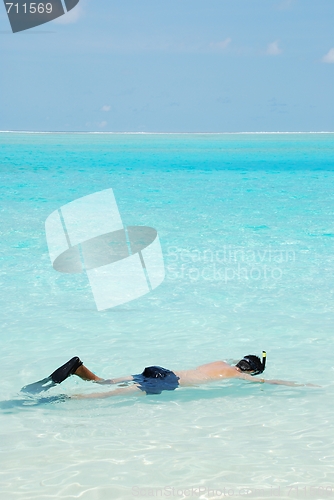 Image of Young man snorkeling in Maldives (blue ocean water)