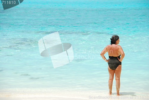 Image of Senior woman looking at blue vibrant ocean