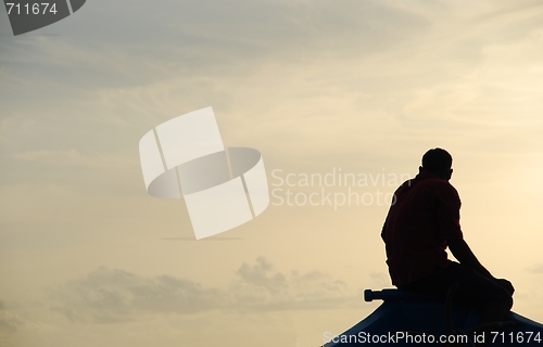 Image of Silhouette of a fisherman on a typical Dhoni boat (sunset)