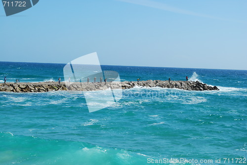 Image of Rock fishing scene on a wavy ocean