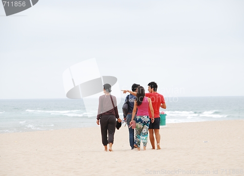 Image of Beautiful family walking on beach