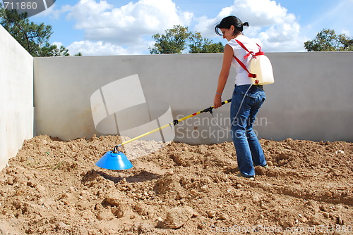 Image of Young farmer fertilizing the soil
