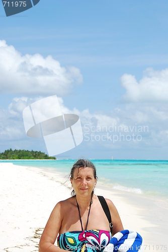 Image of Beautiful senior woman walking on a tropical beach