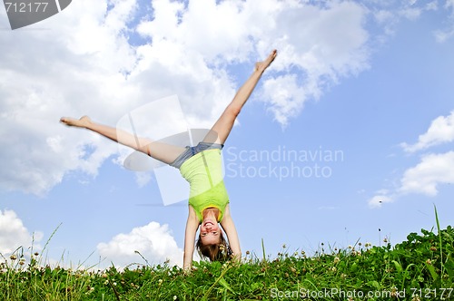 Image of Young girl doing cartwheel