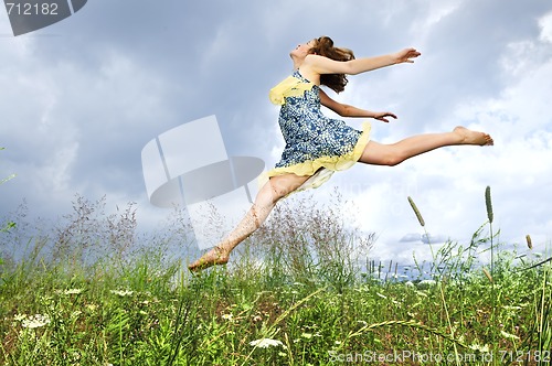 Image of Young girl jumping in meadow