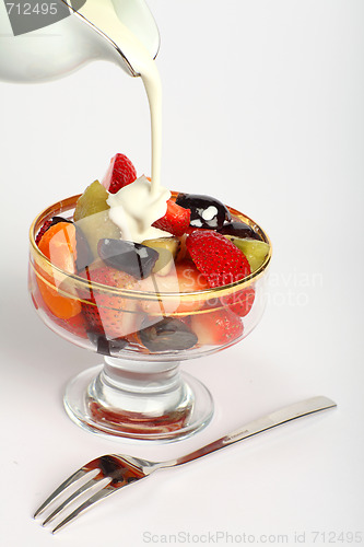 Image of Pouring cream on to fruit salad