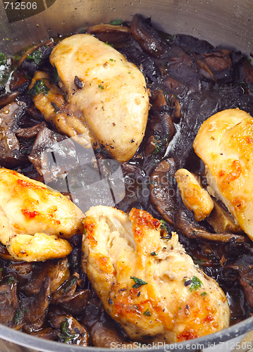 Image of Chickens and mushrooms cooking vertical