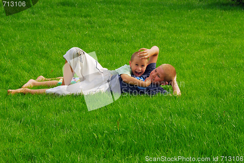 Image of two boys play on the grass