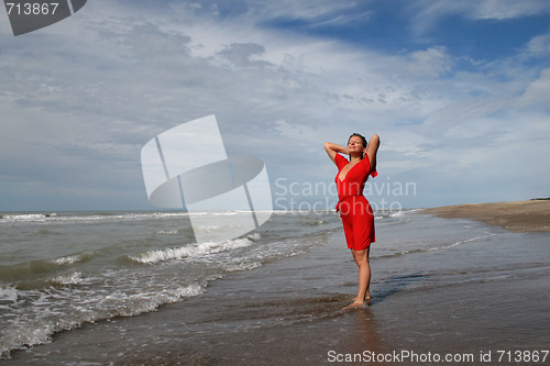 Image of women in red on oceanic coast under blue sky