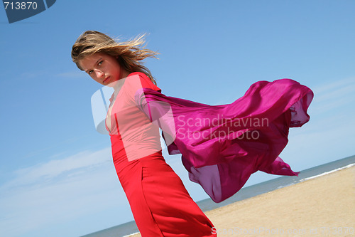Image of young women on beach with red fluttering scarf