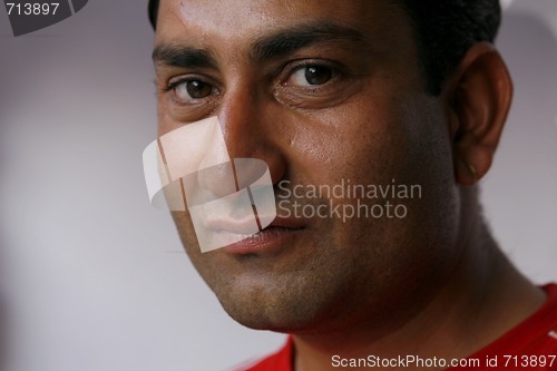 Image of Handsome but serious Indian man looking straight into the camera