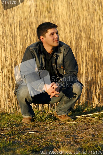 Image of Young man looking aside with a thoughtful look on his face