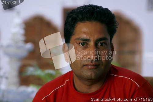Image of Handsome but serious Indian man looking straight into the camera