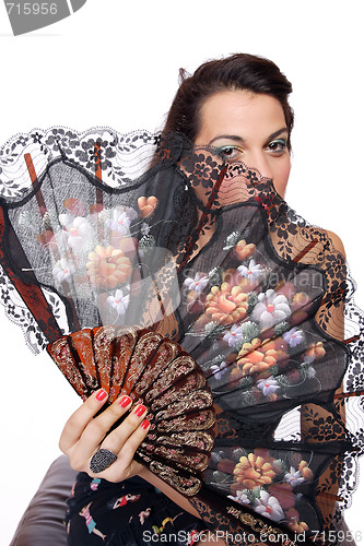 Image of Spanish  woman behind traditional fan.