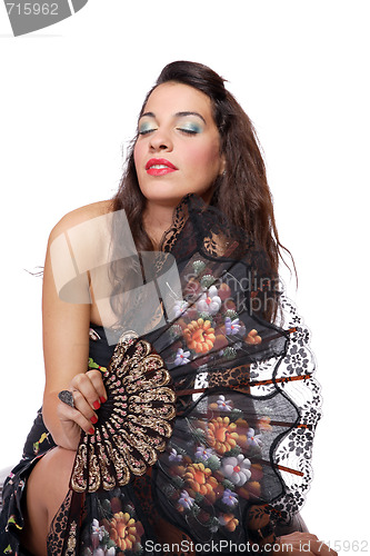 Image of Spanish  woman behind traditional fan.