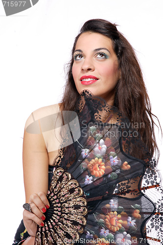 Image of Spanish  woman behind traditional fan.