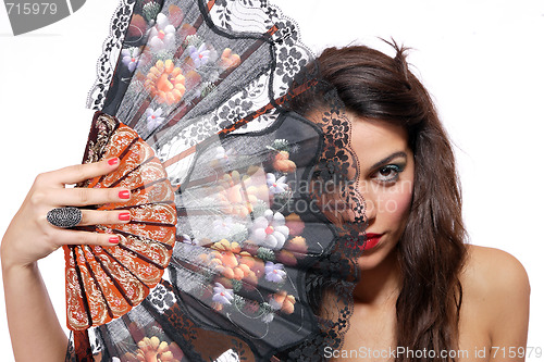 Image of Spanish  woman behind traditional fan.