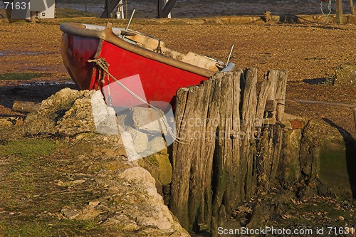 Image of Red rowing boat berthed on land