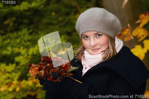 Image of Autumn - Cute young woman holding leaves