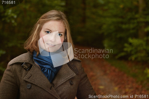 Image of Freindly young woman standing by a forest path