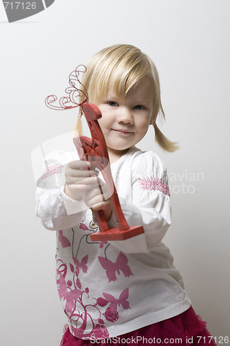 Image of Little girl holding toy reindeer.