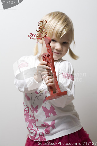 Image of Little girl holding toy reindeer.