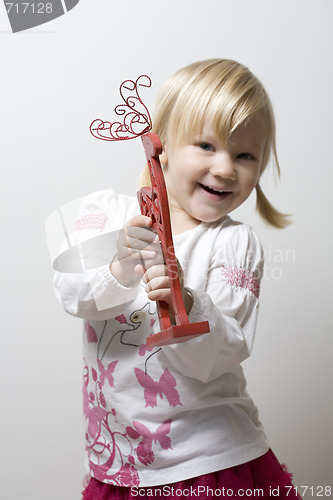 Image of Happy little girl holding toy reindeer.