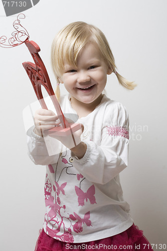 Image of Happy little girl holding toy reindeer.